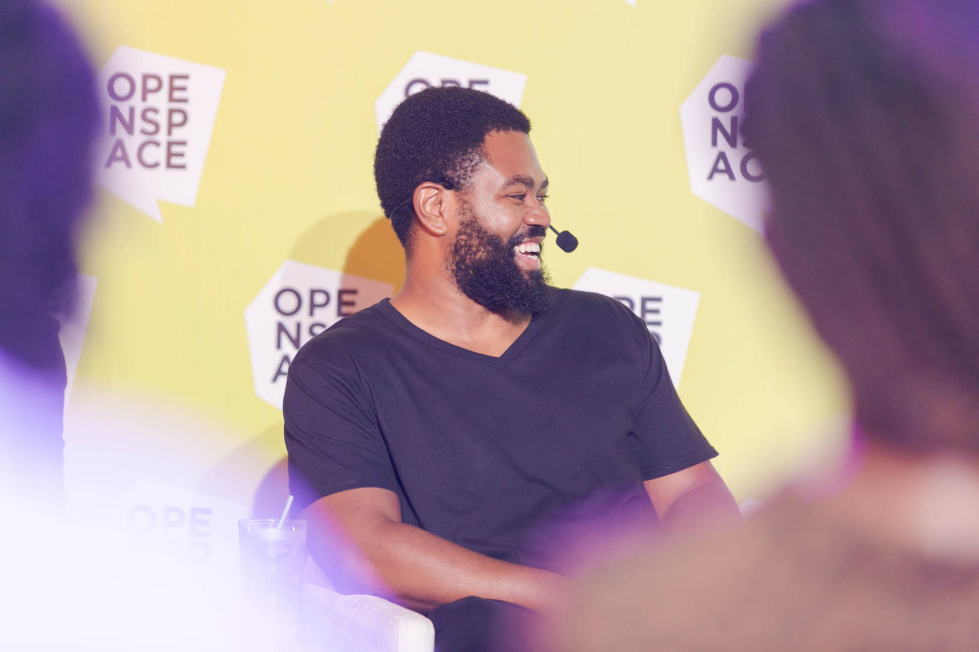 A speaker in front of the OPENSPACE backdrop